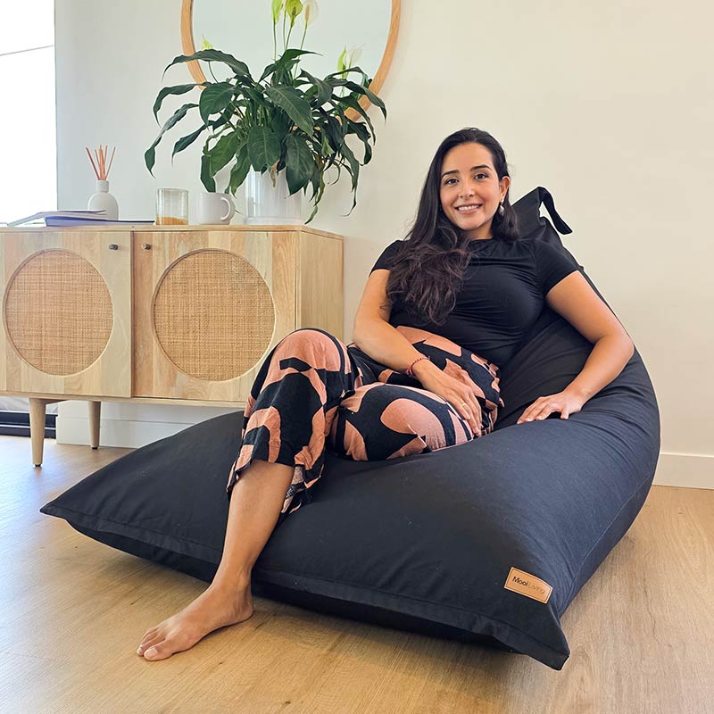 Black Modern Cotton Canvas Triangle Indoor Bean Bag Chair by Mooi Living in a contemporary living room, woman seated.
