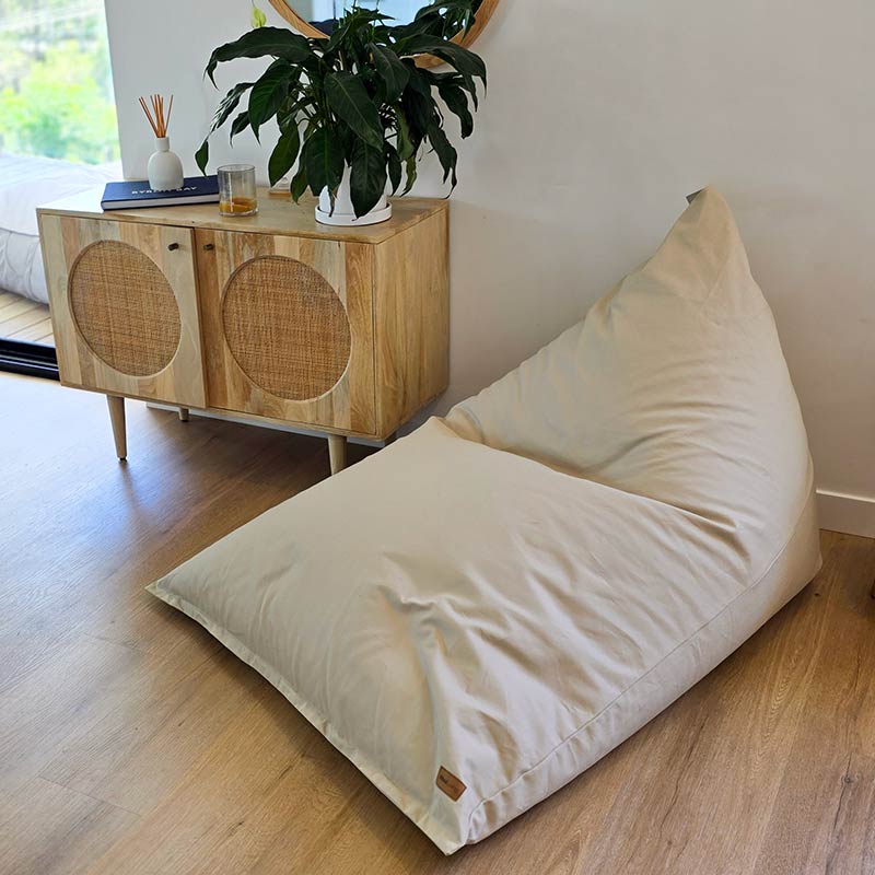 Natural Large Cotton Canvas Triangle Bean Bag Chair by Mooi Living on timber flooring.