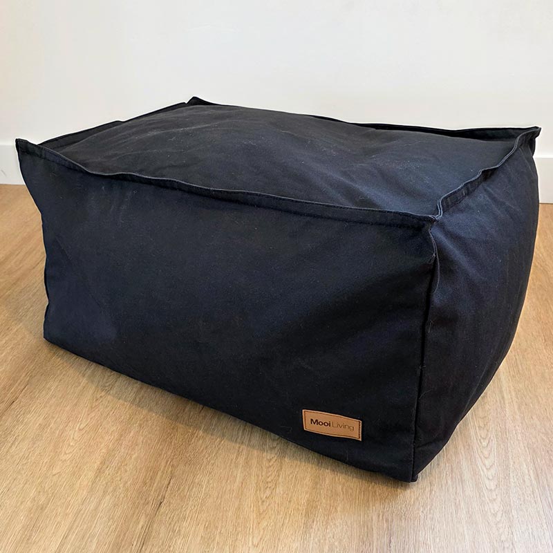 Black 100% Cotton Canvas Boss Ottoman by Mooi Living placed against a wall in a modern interior.