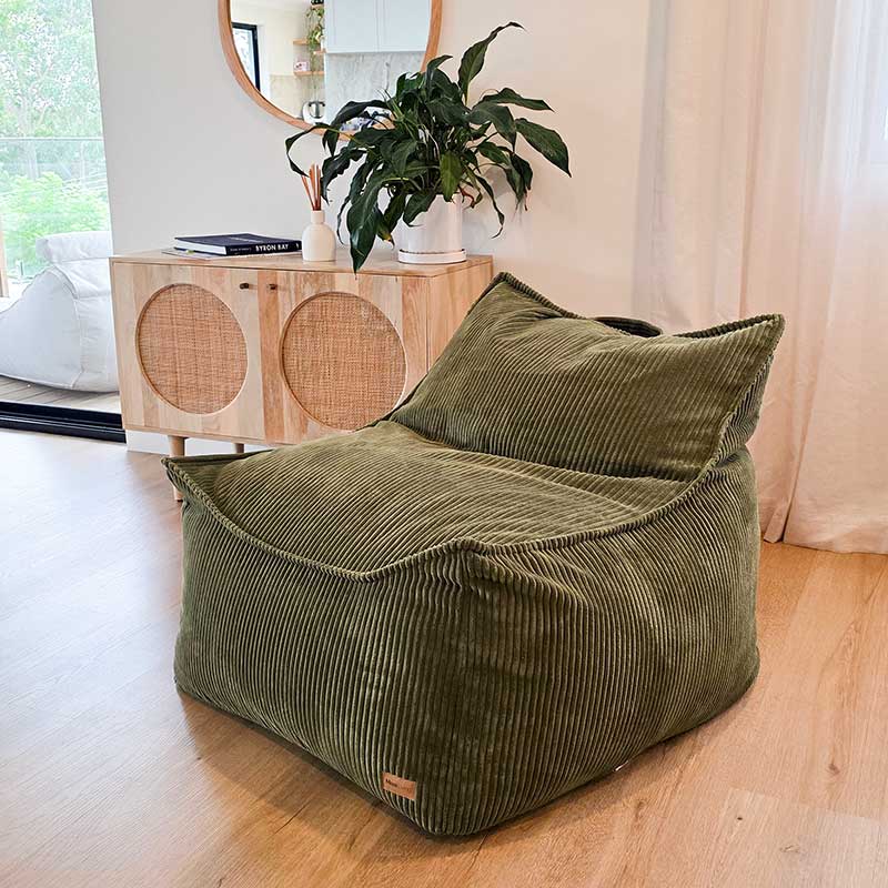 Olive green corduroy bean bag chair styled in a modern living room