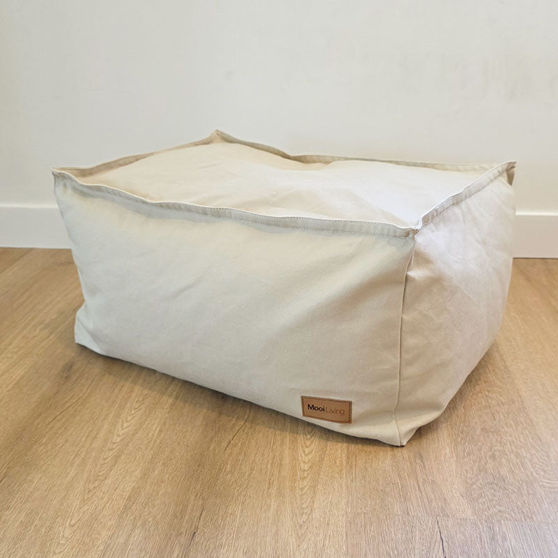 Natural 100% Cotton Canvas Boss Ottoman by Mooi Living placed against a wall in a modern interior.