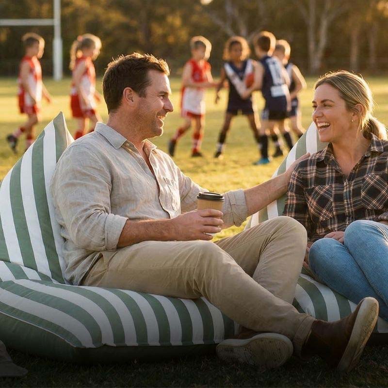 Parents relaxing on reversible triangle bean bags outdoor bean bag by Mooi Living, while watching kids' sports on the sidelines, lightweight portable seating for weekend games.