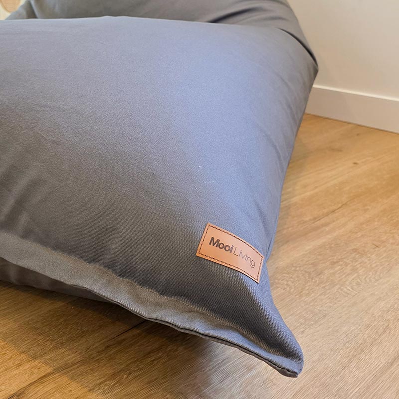 Close up of our Mocha Cotton Canvas Triangle lounge chair by Mooi Living. Show's fabric and Mooi Living logo.