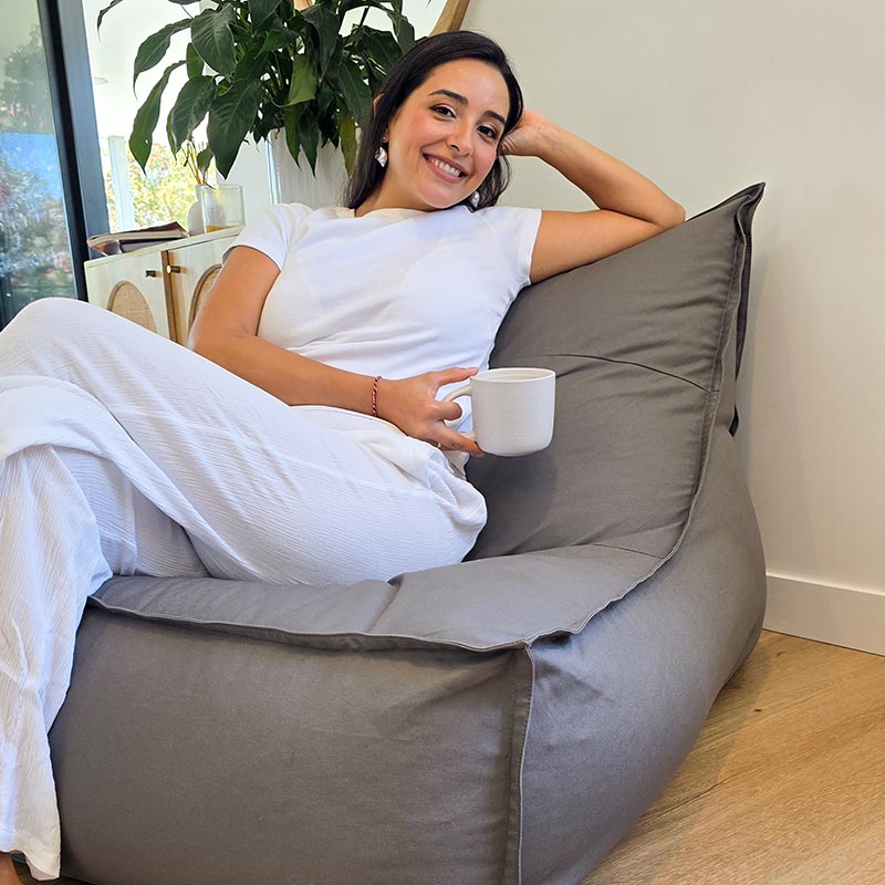 Woman seated on the Mooi Living Single Boss Bean Bag indoor bean bag by Mooi Living in Mocha 100% cotton canvas within a modern Australian living room.