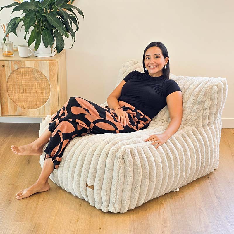 Brooklyn Luxe Lounger Foam Filled Bean Bag in Corduroy Faux Fur indoor bean bag by Mooi Living in a living room, woman seated.