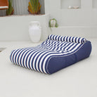 Mooi Living Navy Stripe Nevaeh double outdoor bean bag sunbed on a white patio, showing navy and white stripes and a matching bolster cushion, MOSTNEVBB-STRI-NAV