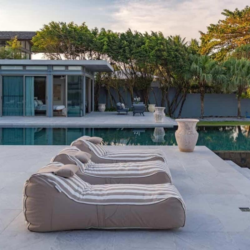 Three Taupe Stripe Cojelo Suave Sunloungers outdoor bean bag by Mooi Living placed side by side poolside at Villa Essenz Natai, customer photo by @Villa_essenza_natai.