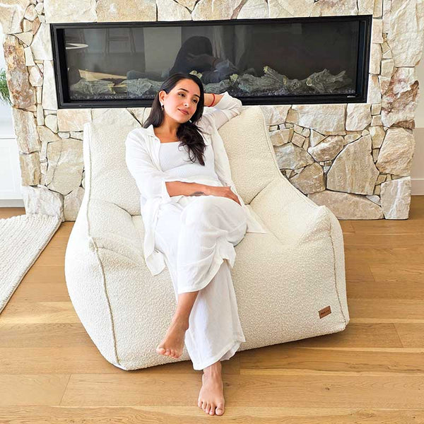 Cream Bouclé Serena Armchair Bean Bag by Mooi Living in a light-filled living room, woman seated.