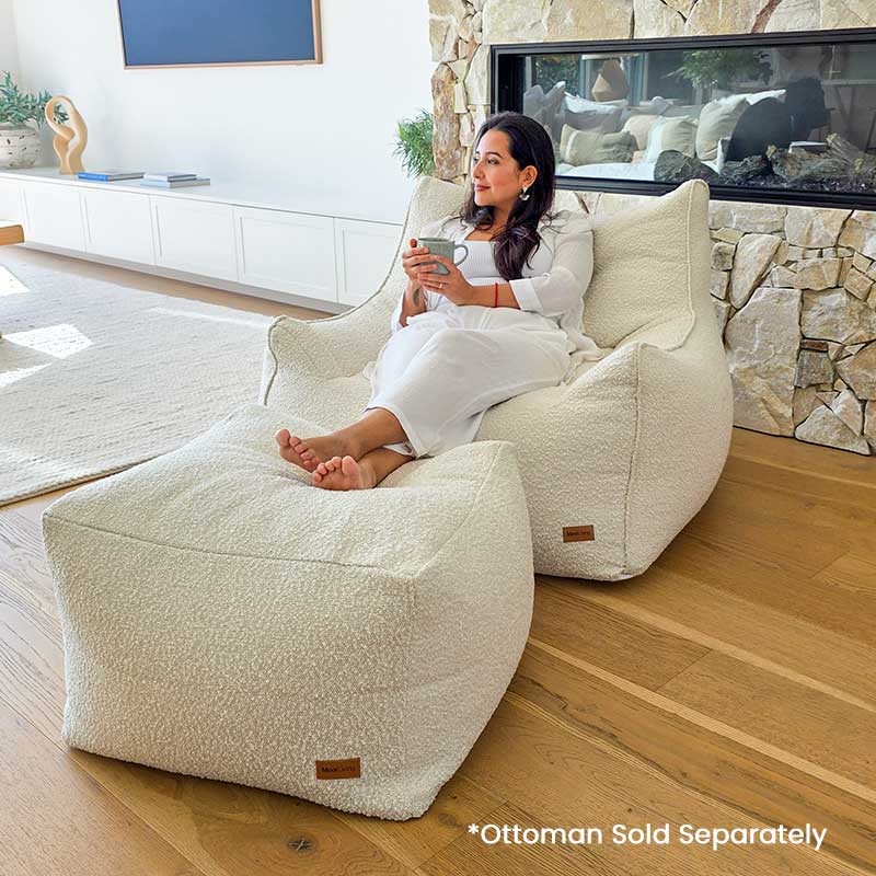 Cream Bouclé Serena Armchair Bean Bag with coordinating ottoman by Mooi Living styled in a modern interior.