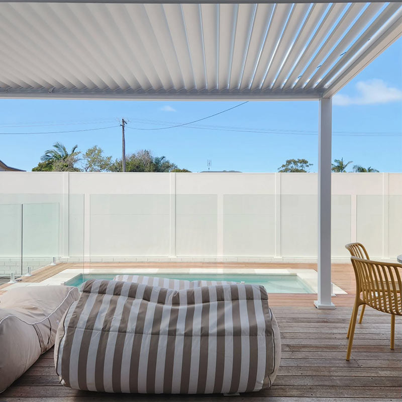 Outdoor patio with Nevaeh Sunbed and Isla Sunlounger outdoor bean bags by Mooi Living, chairs, and pool view