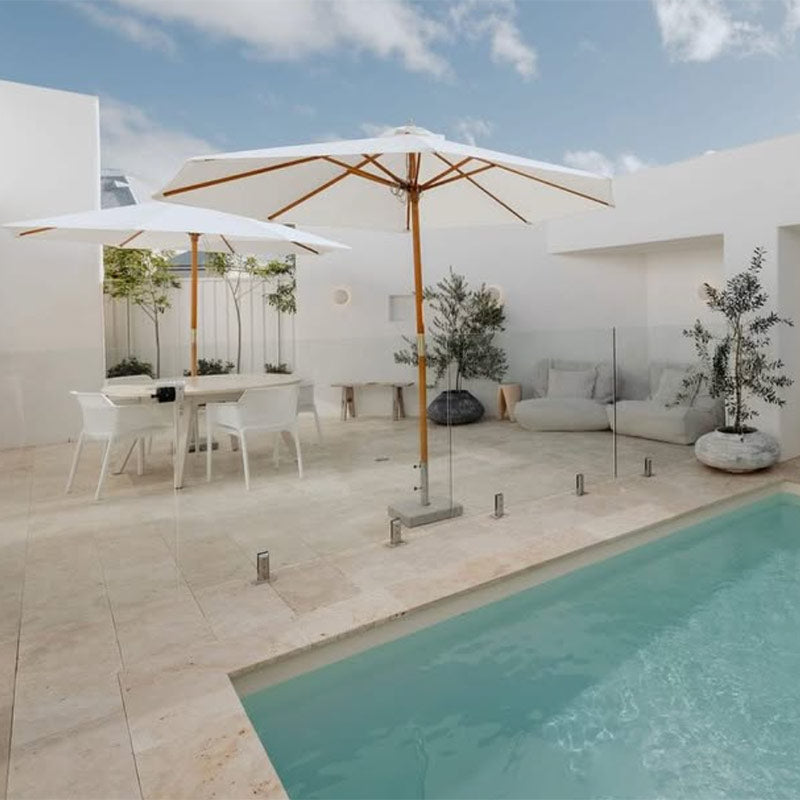 Natural Chill UV Double Seater Bean Bags indoor Bean Bag by Mooi Living. poolside with white outdoor furniture, umbrella, and olive trees, styled by @hudsonyard_design.