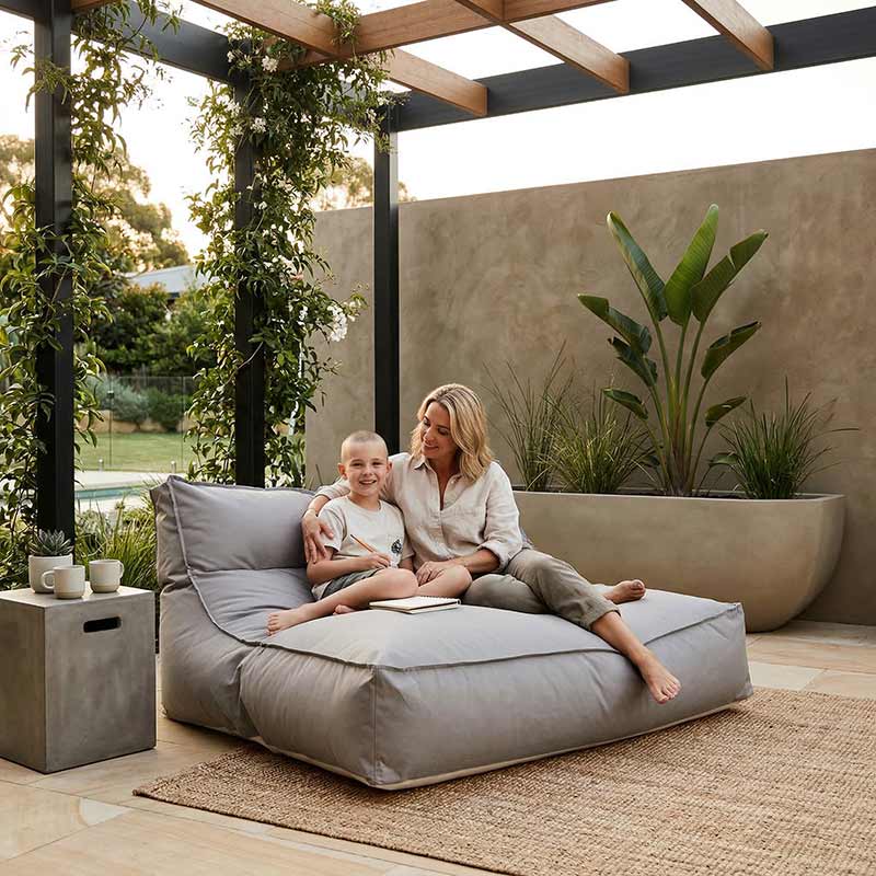 Lifestyle Pic - Modern Australian patio with outdoor furniture, pergola and plants, Stone Lana double seater outdoor lounger bean bag by Mooi Living styled in the corner of the patio, relaxed entertaining space, warm afternoon light.