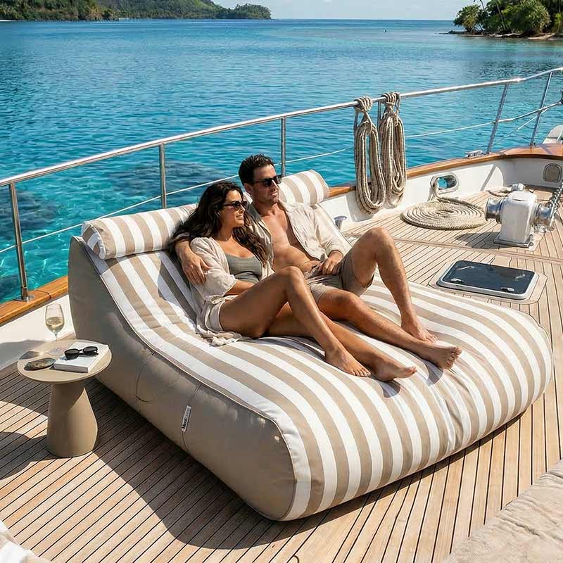 Couple relaxing on a Taupe Striped Nevaeh Sunbed outdoor bean bag by Mooi Living on a yacht with ocean view