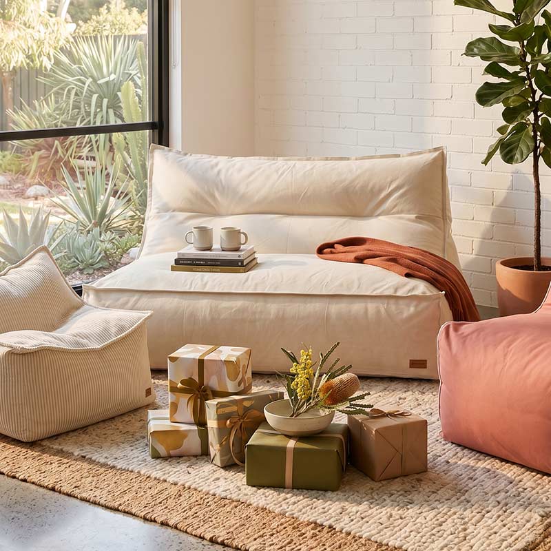 Natural Beige Lana Lounger outdoor bean bag by Mooi Living styled in a modern cozy indoor space with cushions and decorative items on a rug.