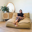 Tan Double Boss double seater bean bag chair by Mooi Living in a light-filled living room, woman seated.